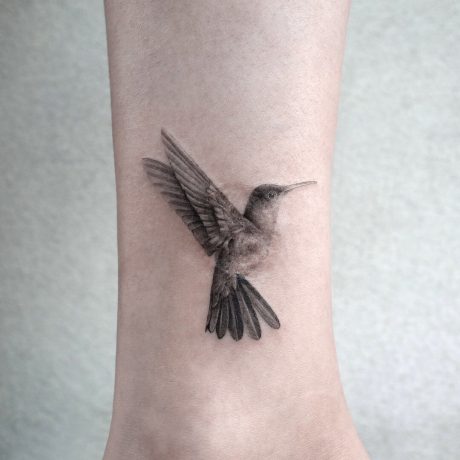 Microrealistic hummingbird tattoo on the calf