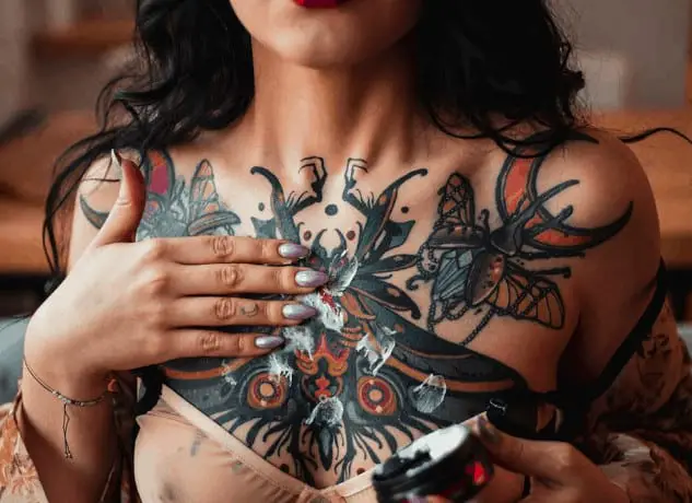 Applying tattoo cream on girl chest