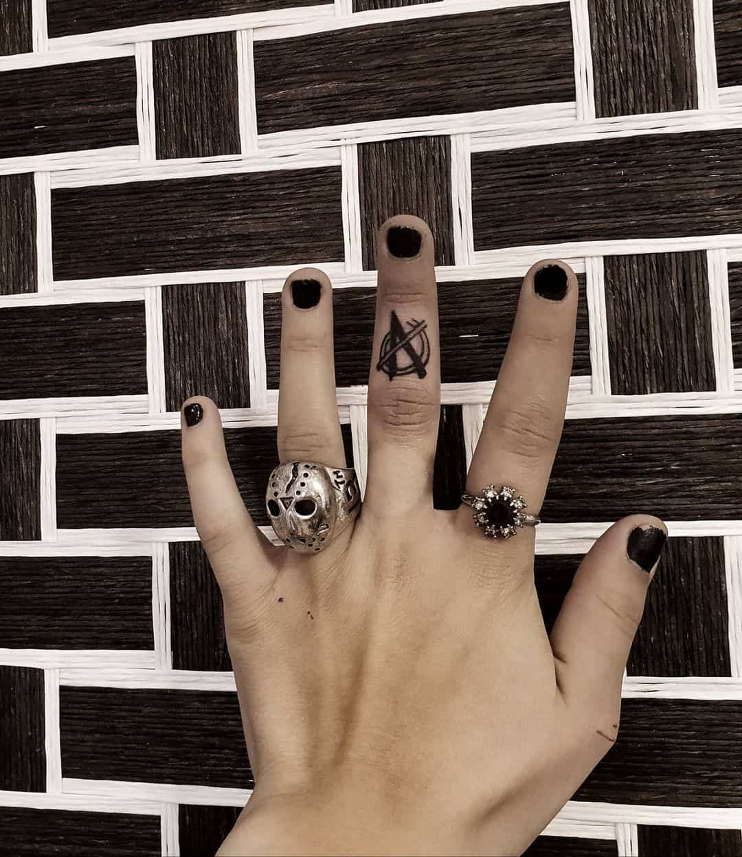 Anarchy tattoo on middle finger