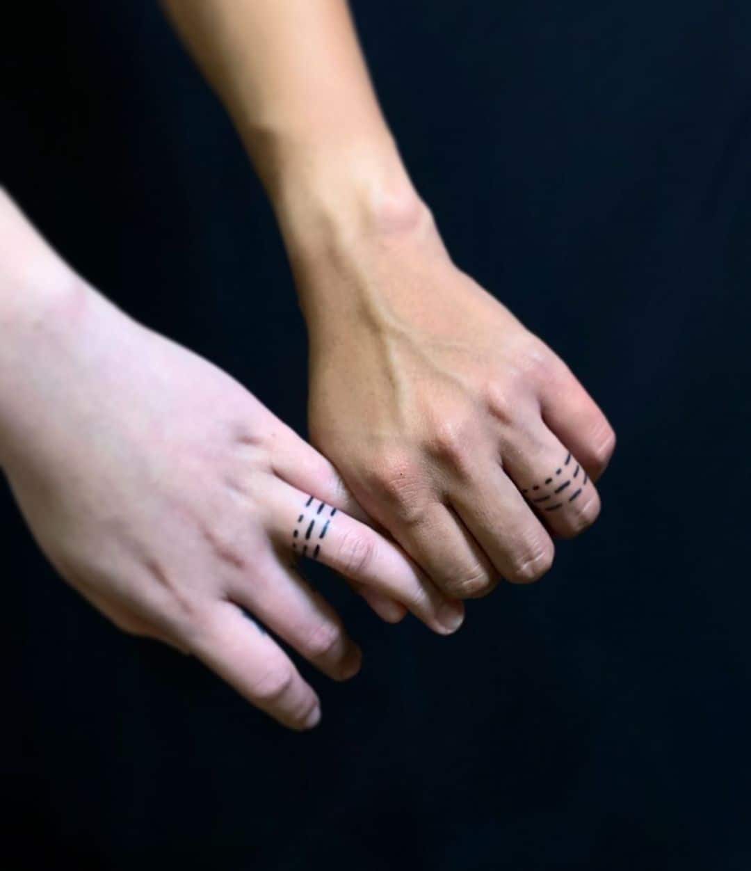 Line wedding ring tattoo on fingers