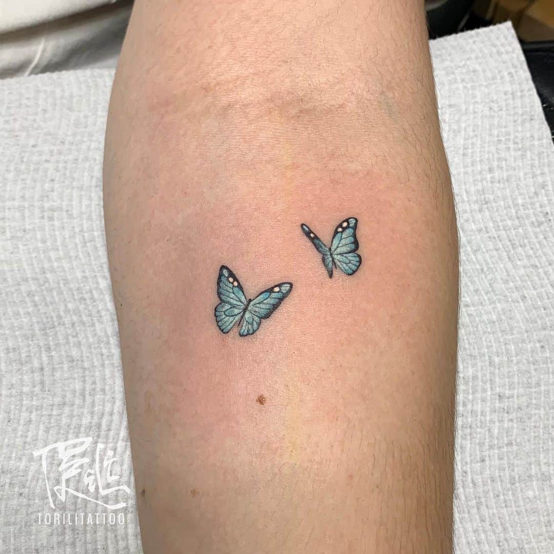 Blue butterfly tattoo on arm