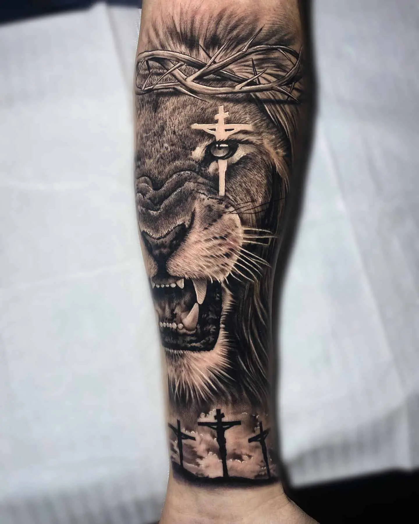 lion and cross tatto on forearm