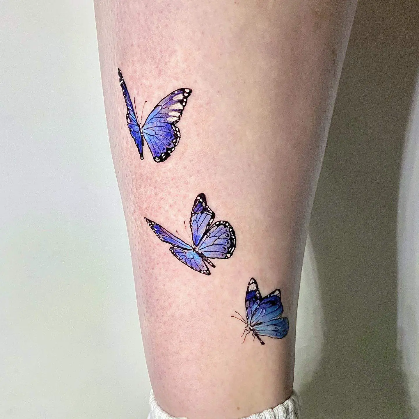 blue butterfly tattoo on leg 