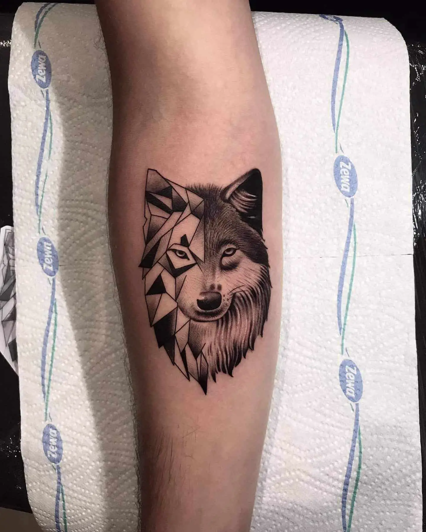 geometric wolf tattoo in forearm