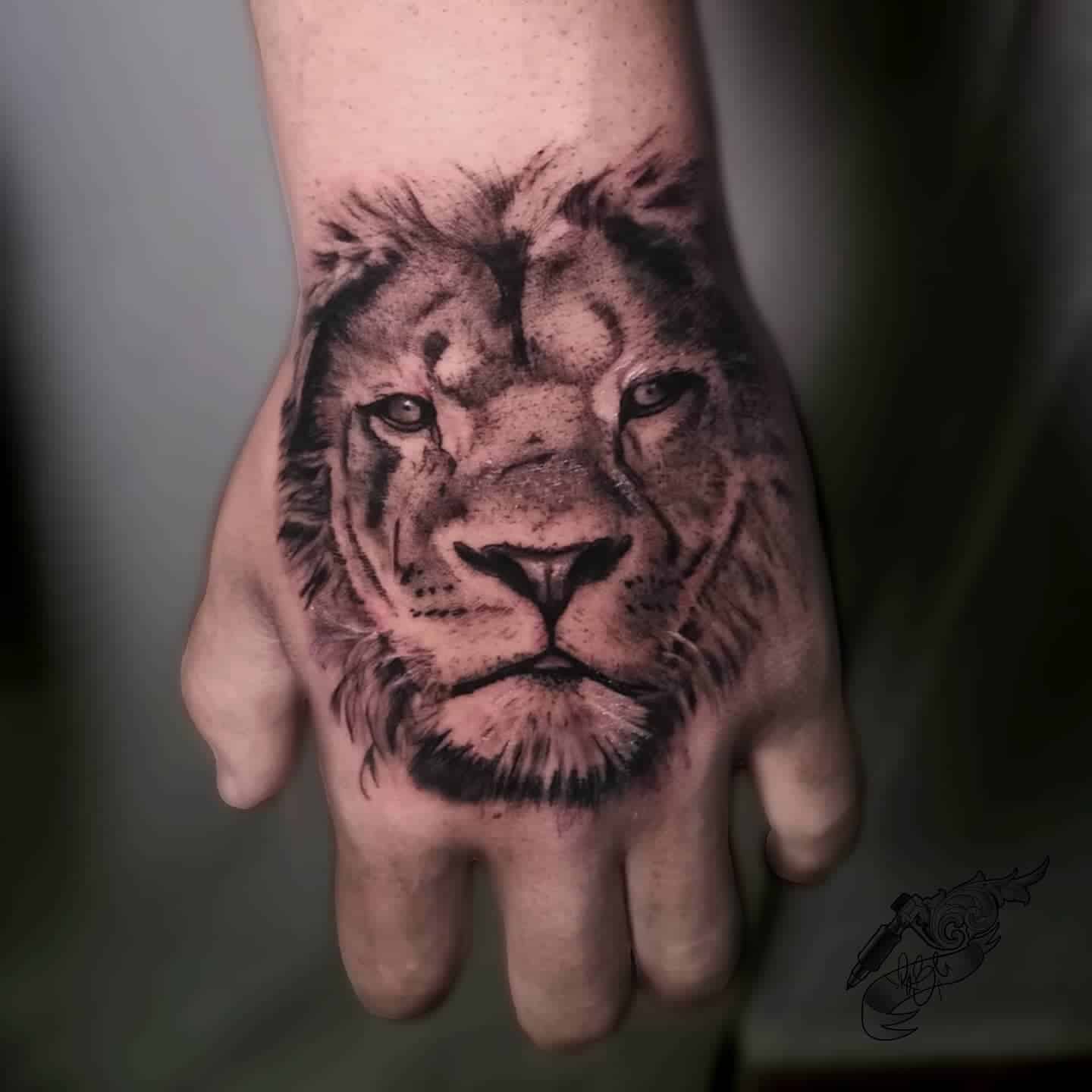 black and grey lion head tattoo on hand