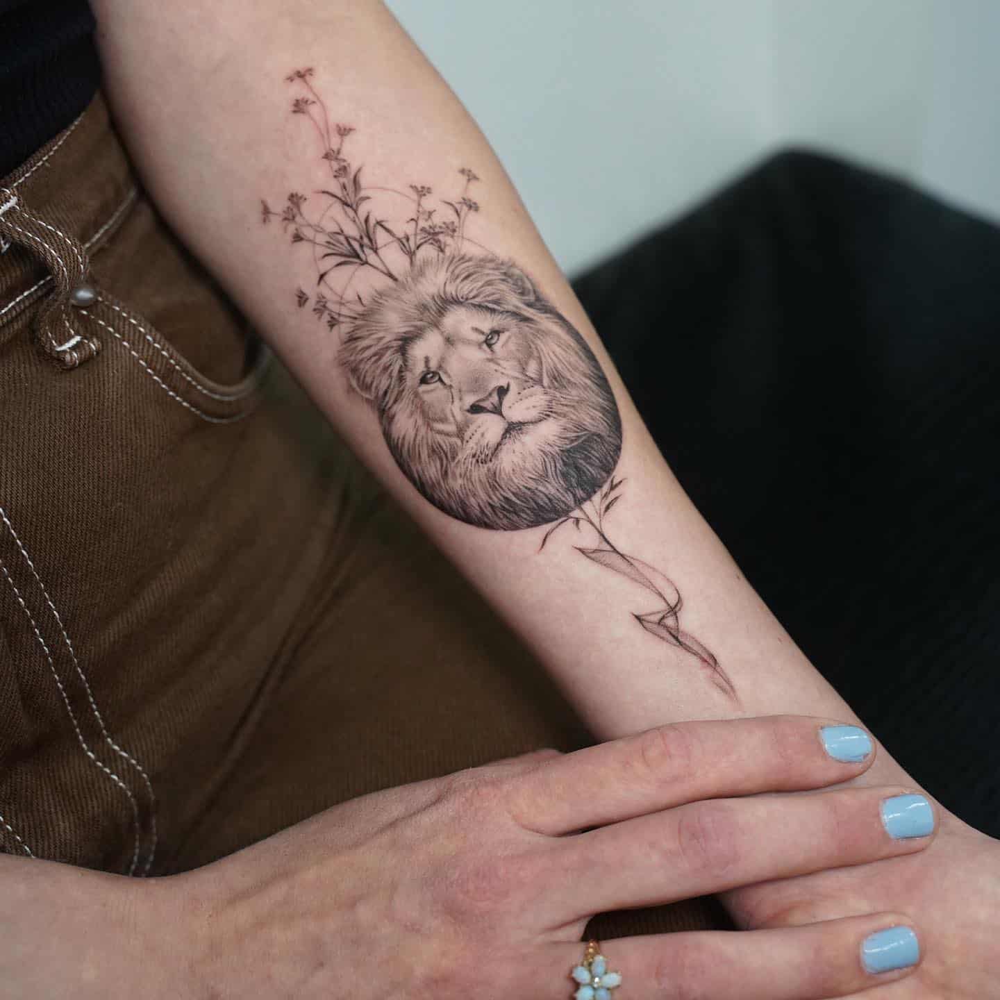small lion tattoo on women forearm