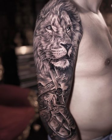 watercolor style lion tattoo on shoulder