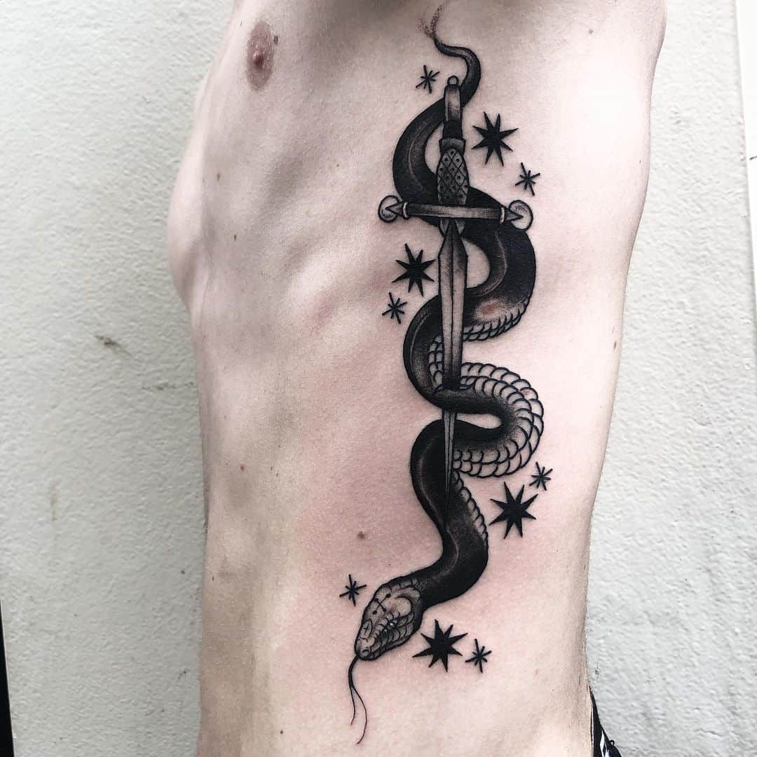 Traditional style snake and sword tattoo