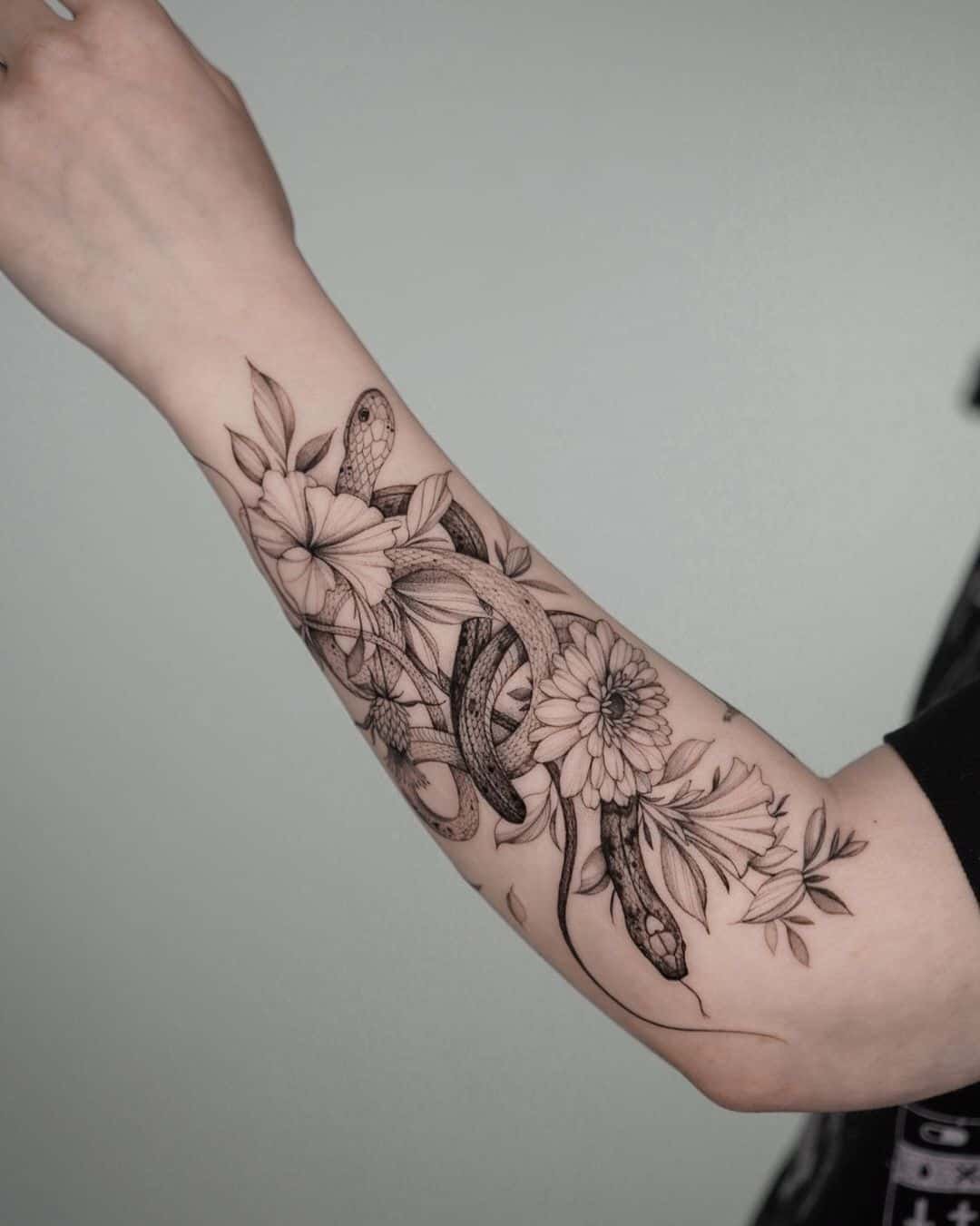 flower and snake tattoo on forearm