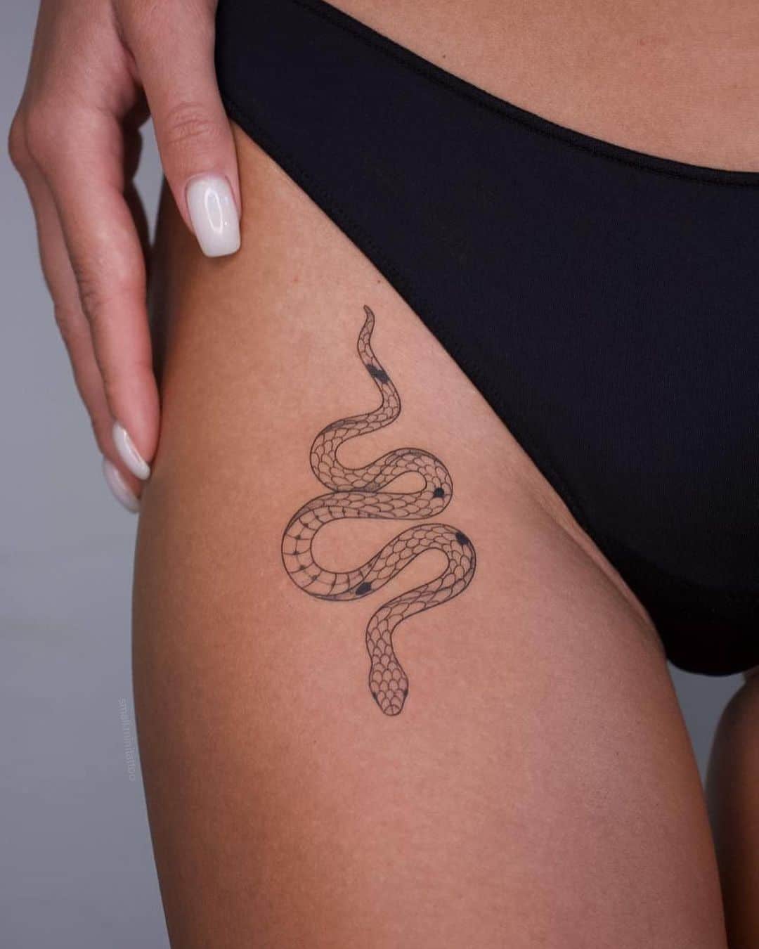 small snake tattoo on thigh