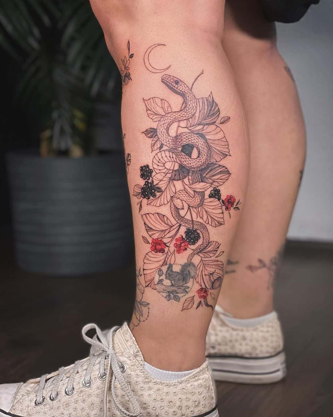 flower and snake tattoo on leg