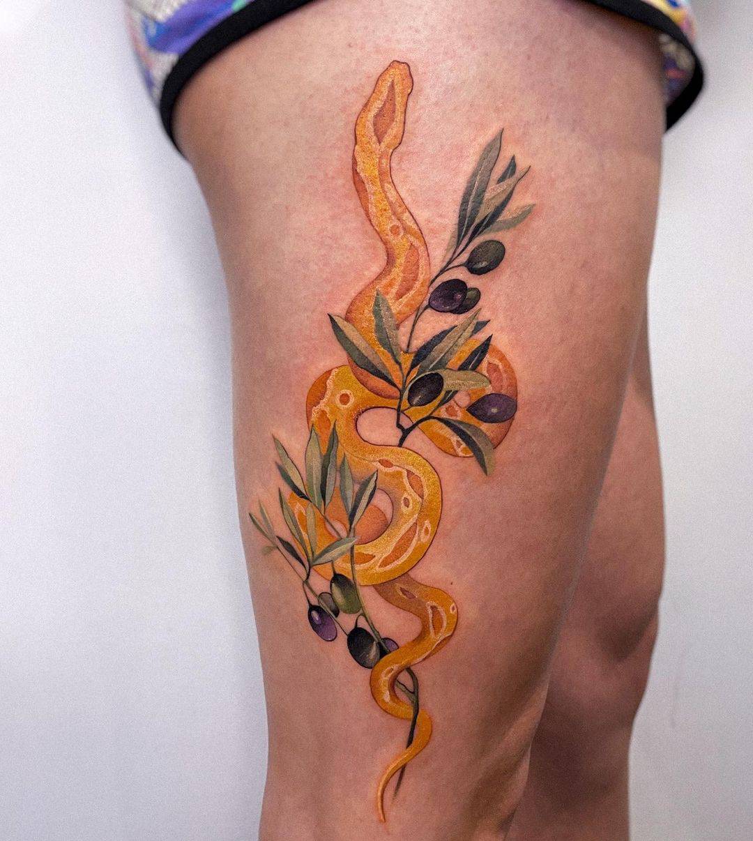 yellow snake tattoo on thigh