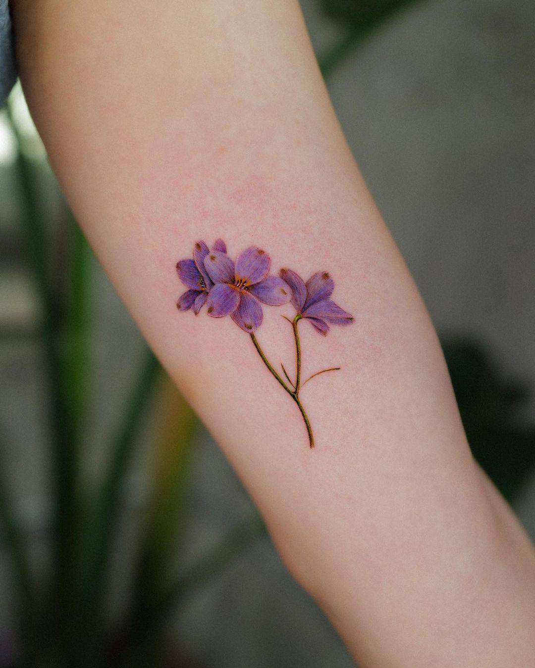 beautiful purple colored flower tattoo