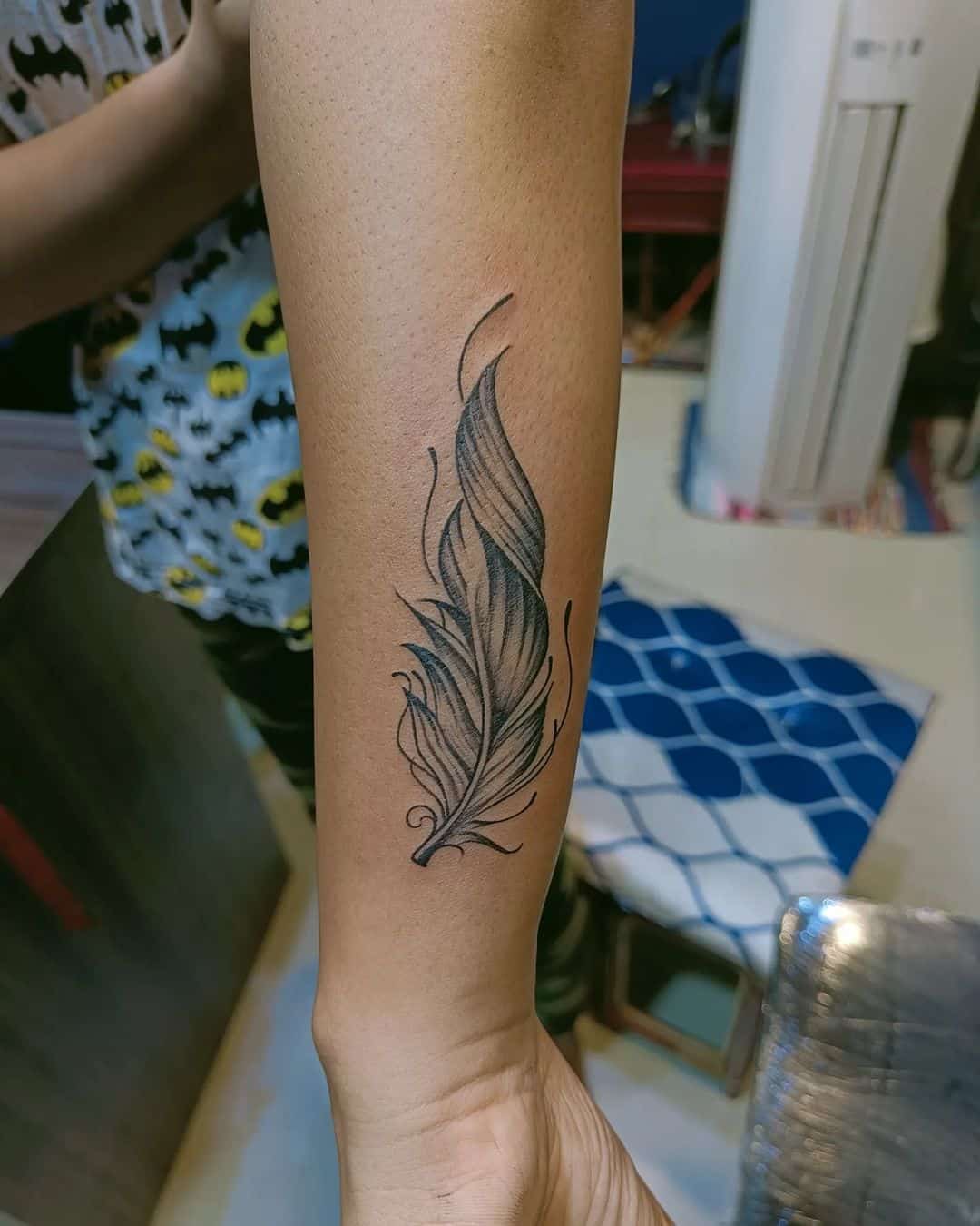 feather tattoo on forearm