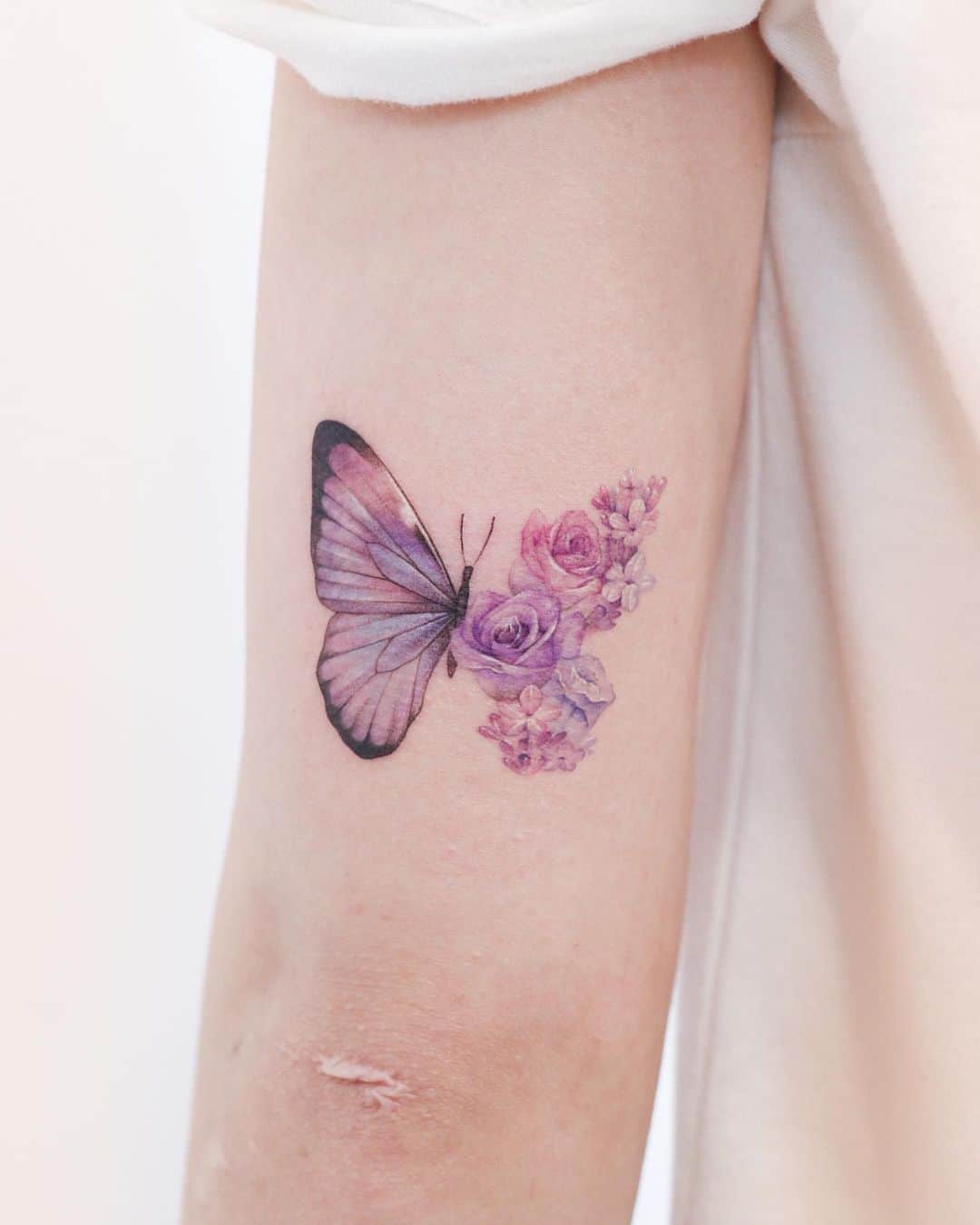 purple butterfly tattoo on arm