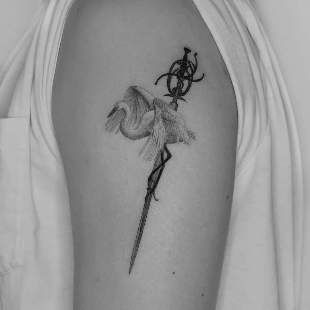sword and crane tattoo on arm
