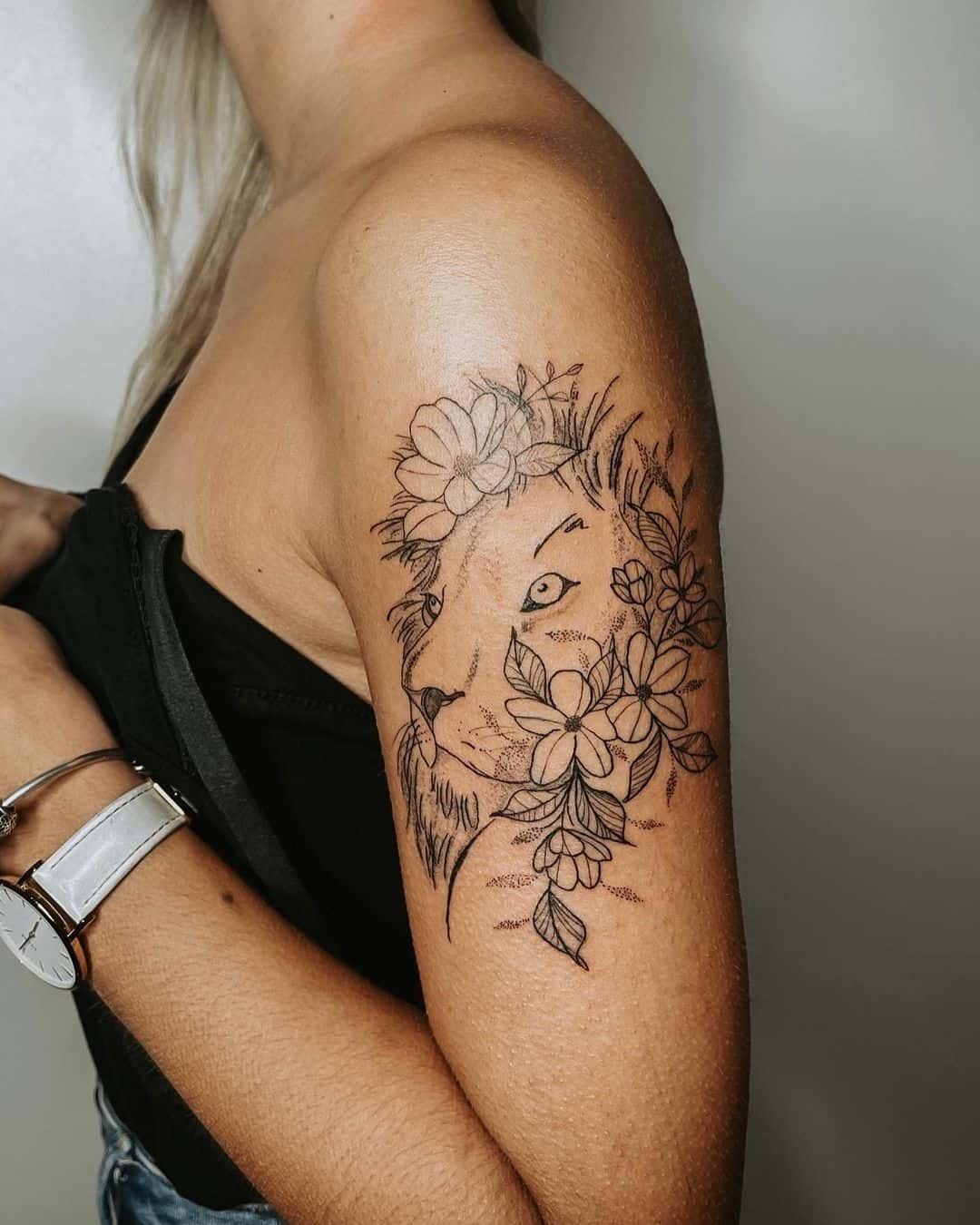 floral and lion tattoo on arm