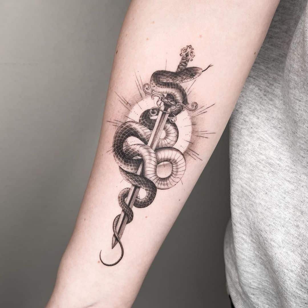 snake and sword tattoo on arm 