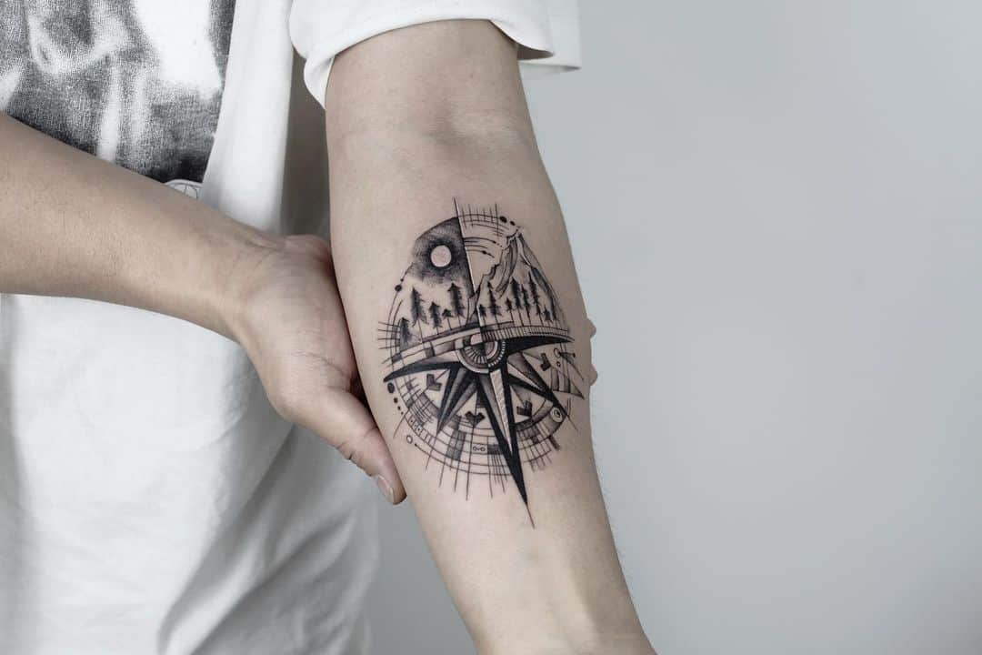 Compass Forearm Tattoo with montain and trees