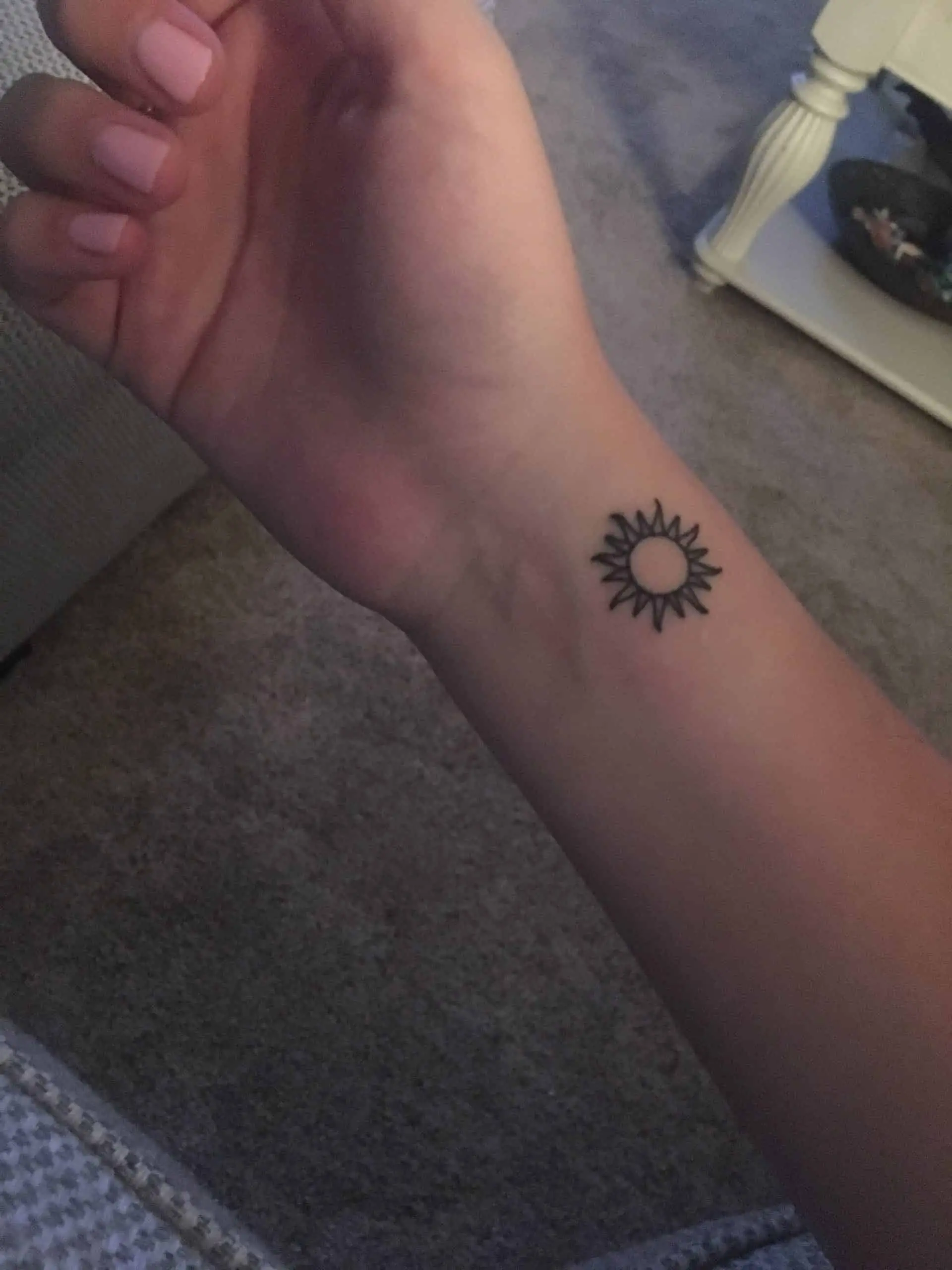 Black and grey Sun tattoo idea for the wrist