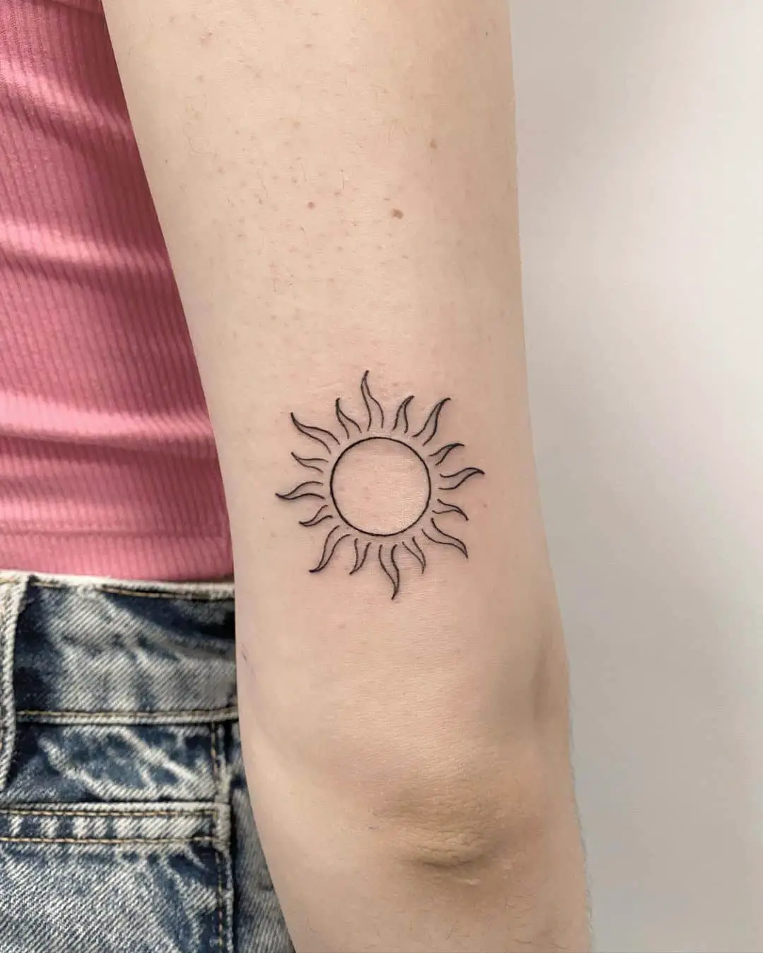 Small Sun Tattoo on upper arm