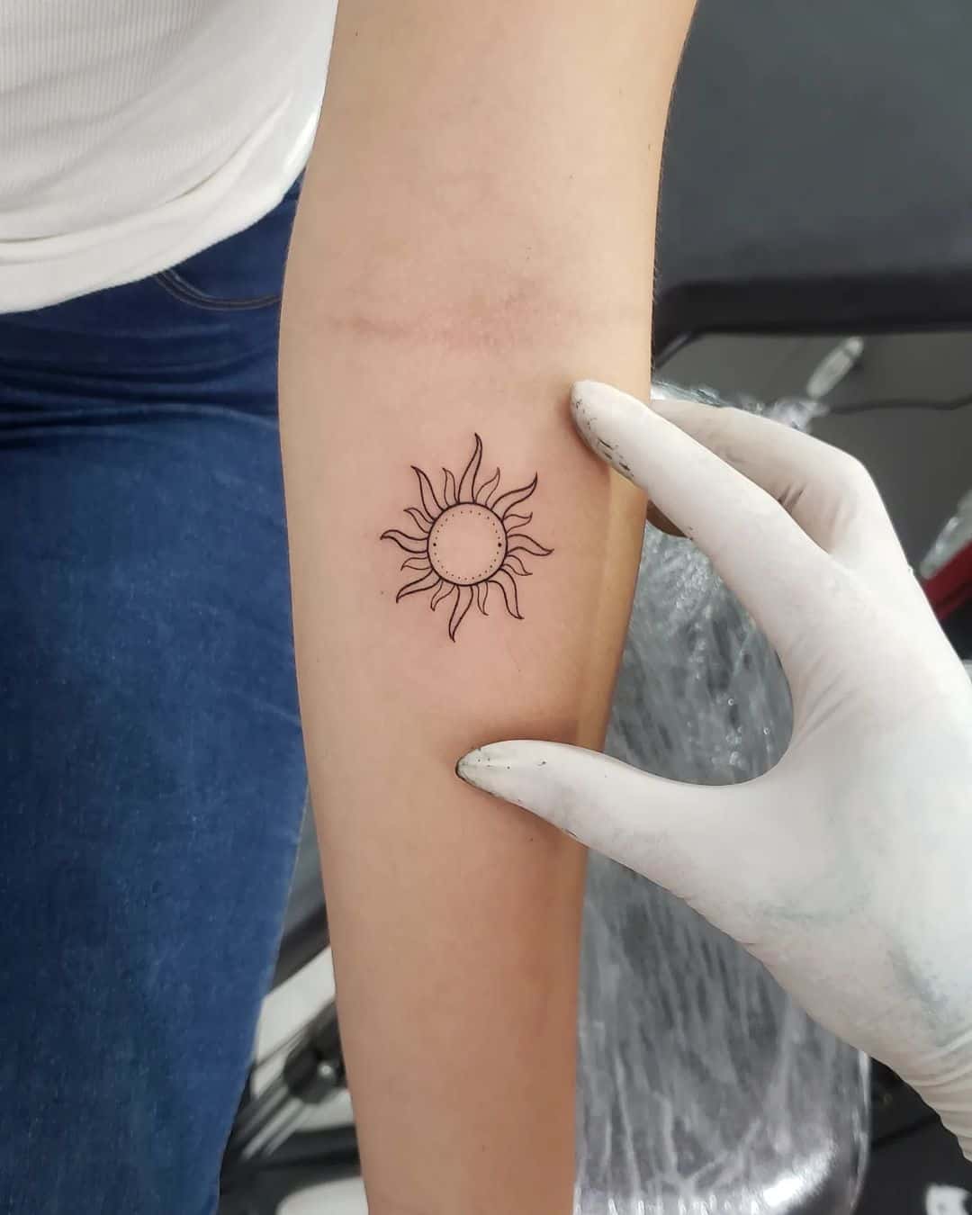 simple sun tattoo design on forearm