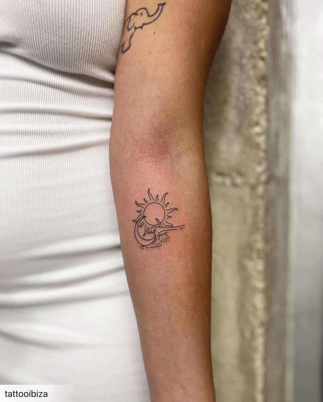 Sun and moon tattoo on lower arm