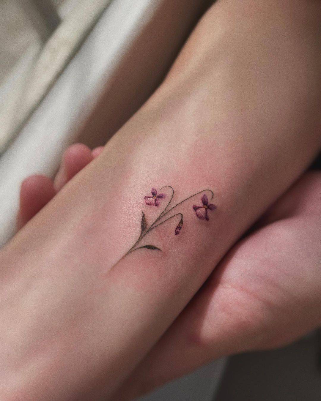 Cute violet tattoo on wrist by jehlickou