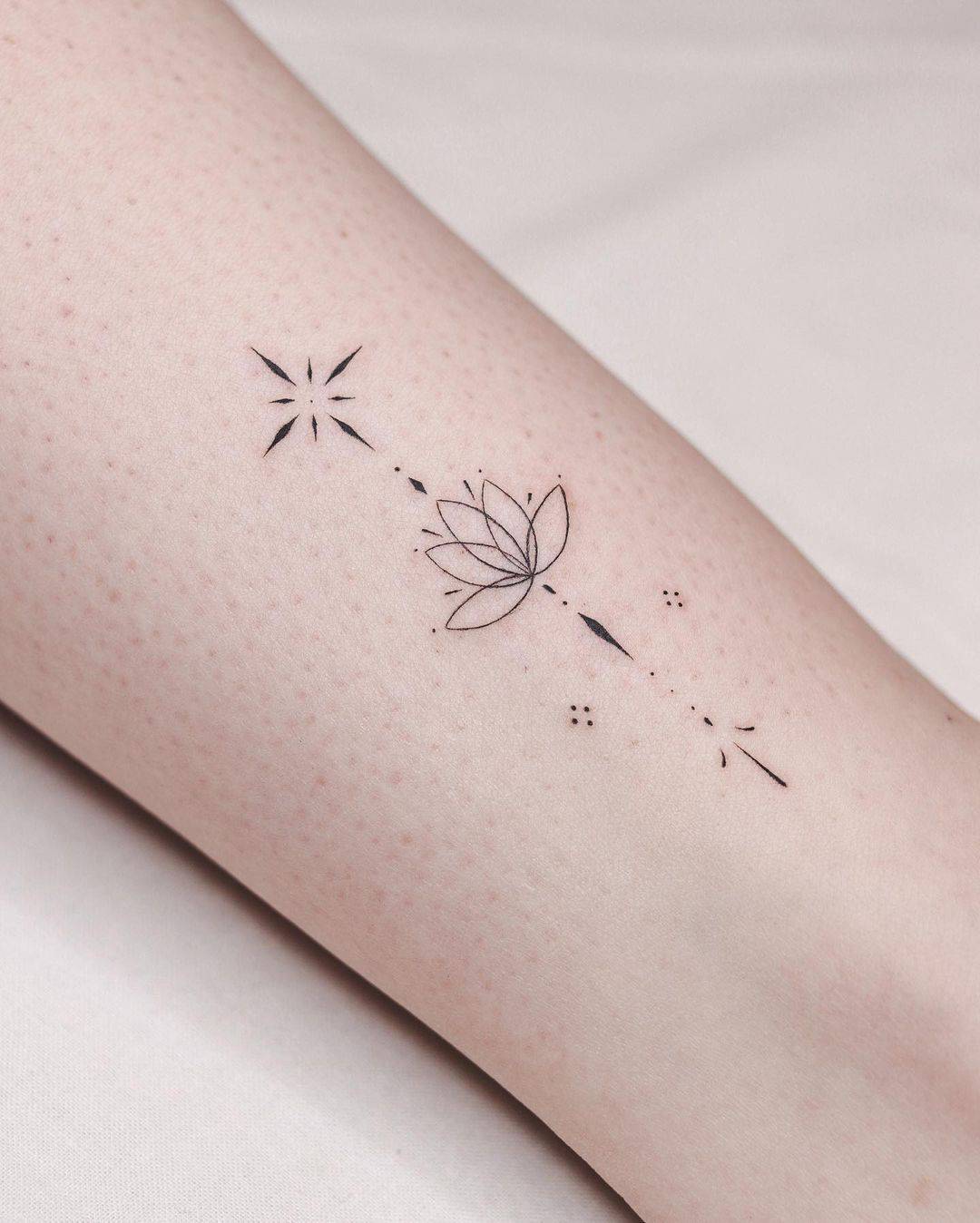 Lotus tattoo with star on arm by orma tattoo