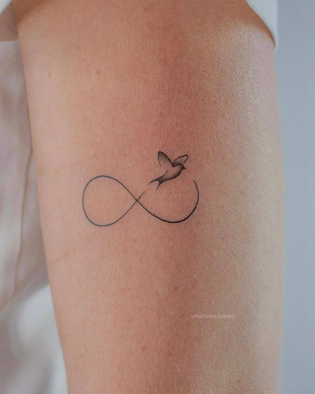 Small bird tattoo with infinity by small.minitattoo
