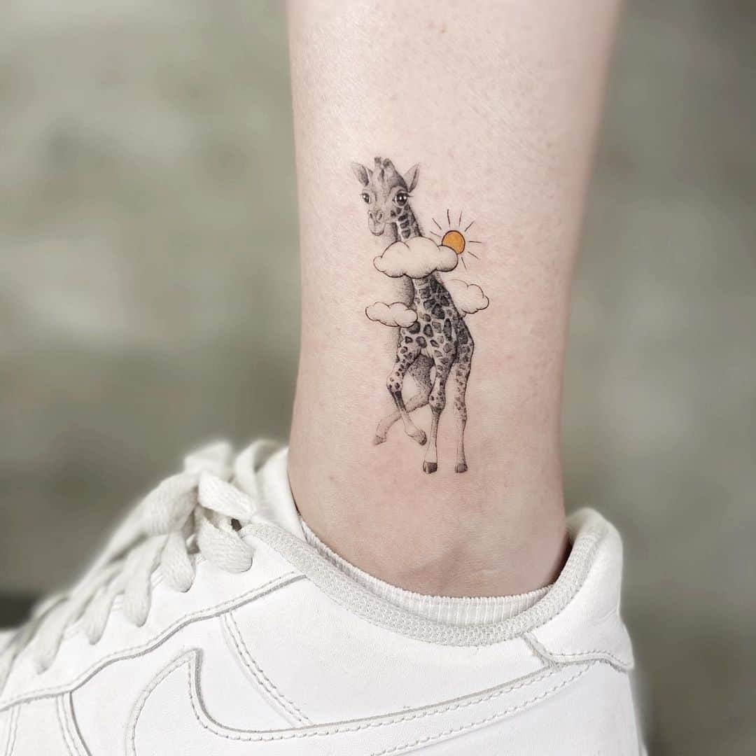 Cute giraffe tattoo on ankle by esertuncertattoos