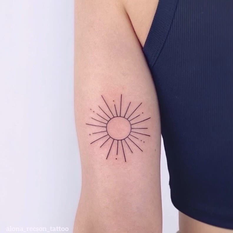 Simple sun tattoo on upper arm by sugar ink alona