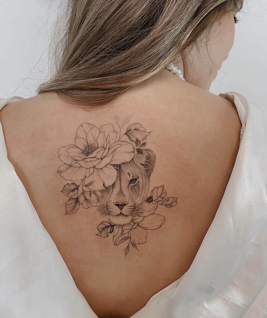 Amazing lioness tattoo with flower on back by sharon tattoos