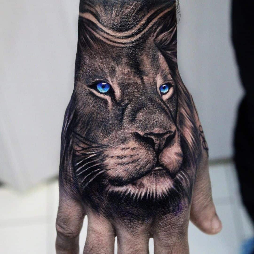 Beautiful blue eye lion portrait tattoo on hand by cristianogiovannini tattoo