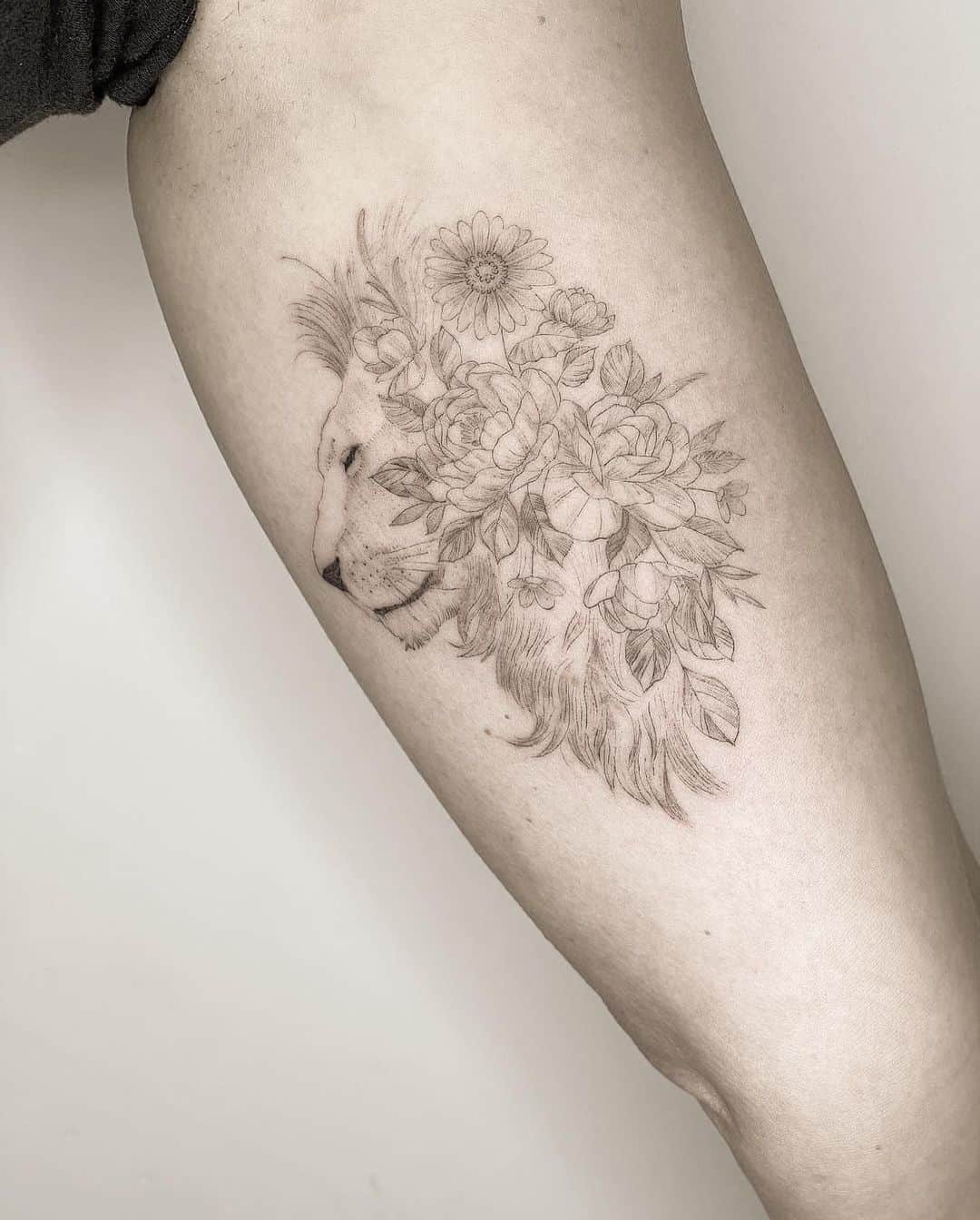 Beautiful lion and flwer tattoo on upper arm by tattoo4unyc