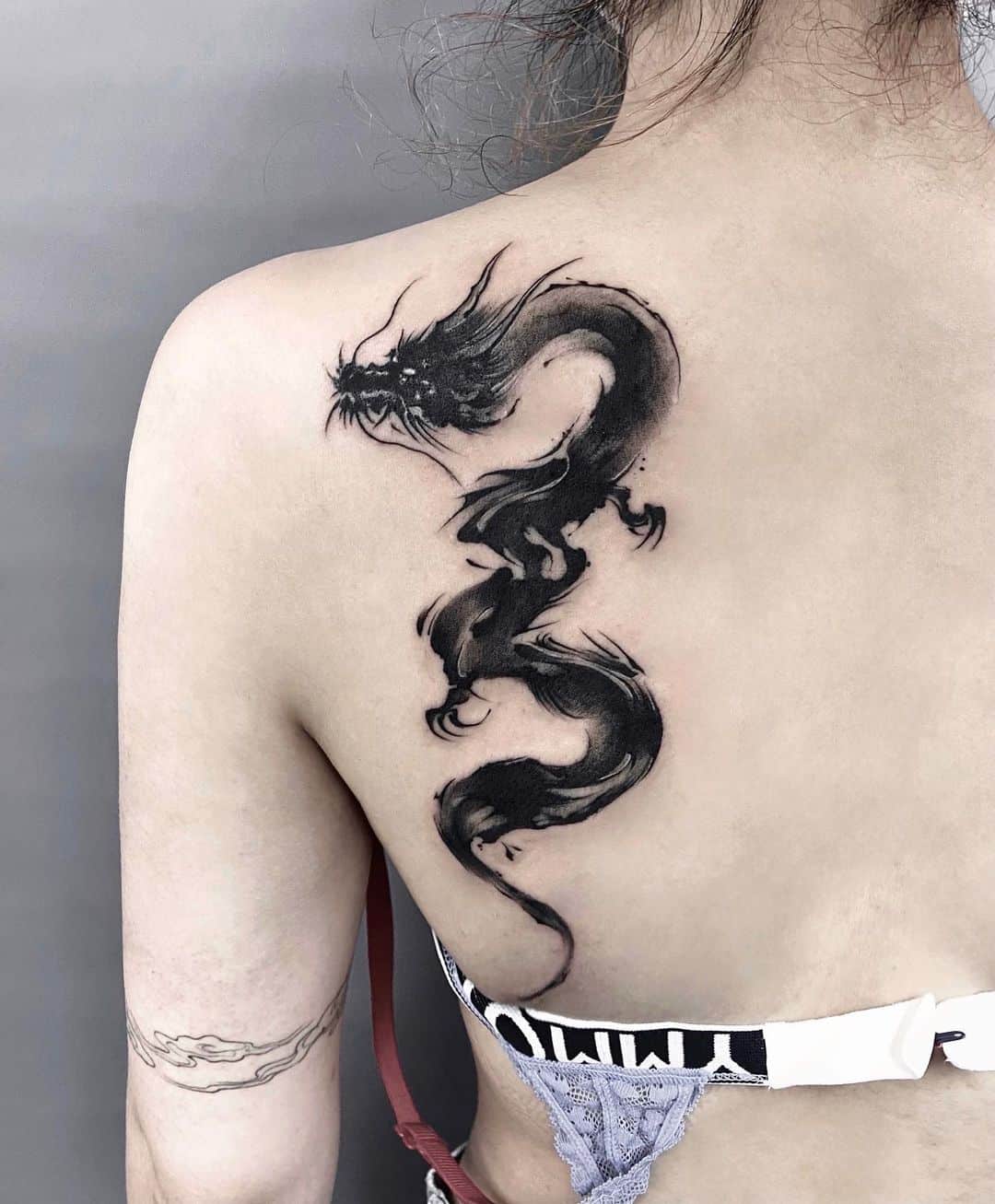 Black inked dragon tattoo by jing.tattoo