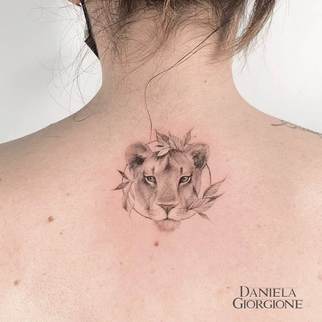 Realistic style lioness tattoo on the left upper arm.