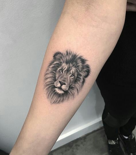 Lion face tattoo on forerm