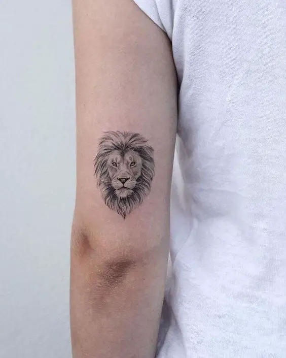Small lion tattoos on upper arm