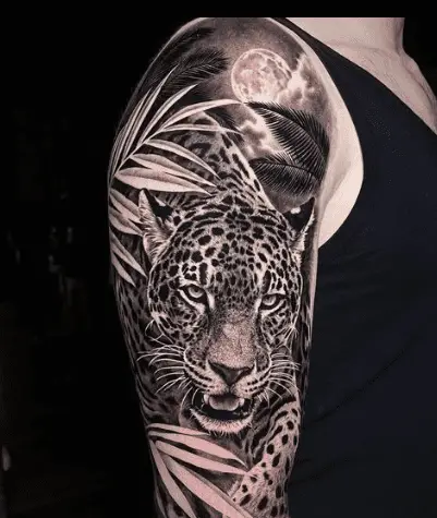 Leopard tattoo with plant on arm by boundless tattoos