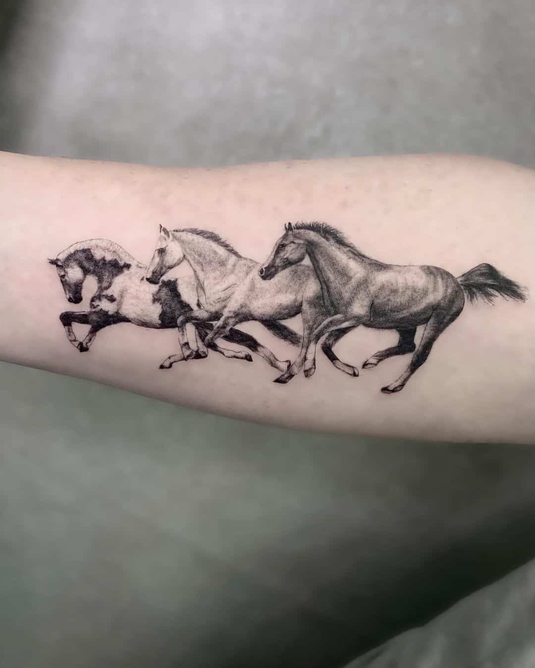 Running horses tattoo on arm by c