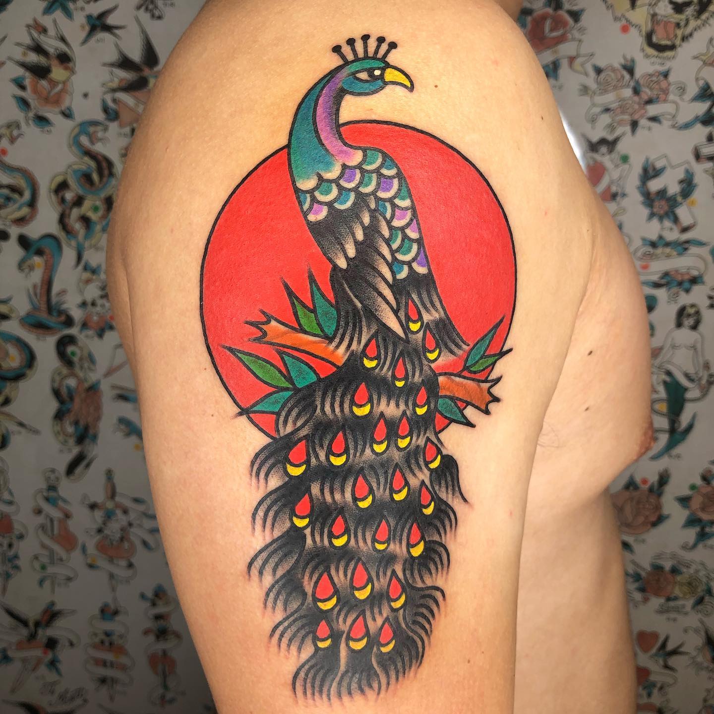 Peacock tattoo on upper arm by