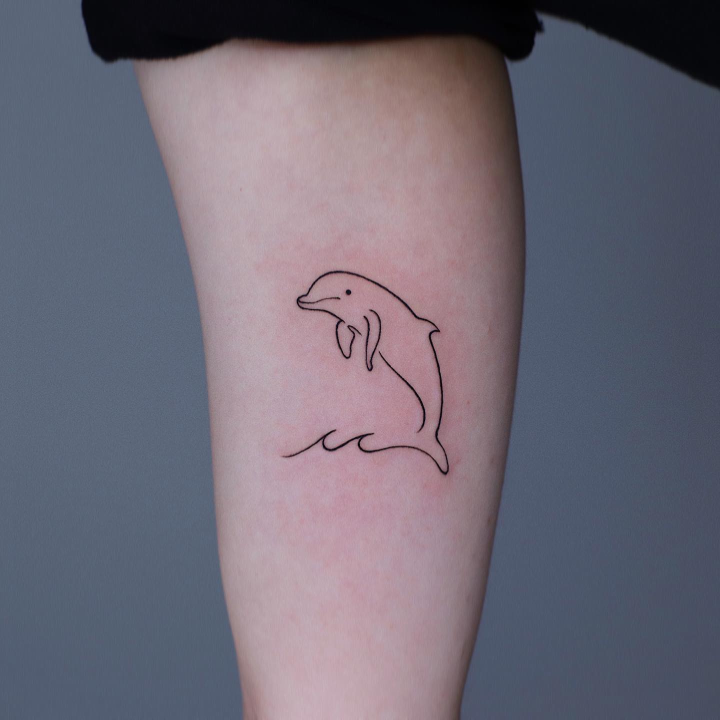 Small dolphin tattoo by howdy tattoo