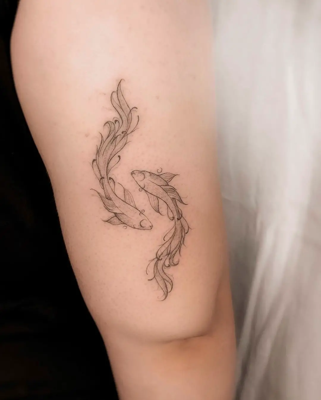 Two fish tattoo by 7needles.tattoo