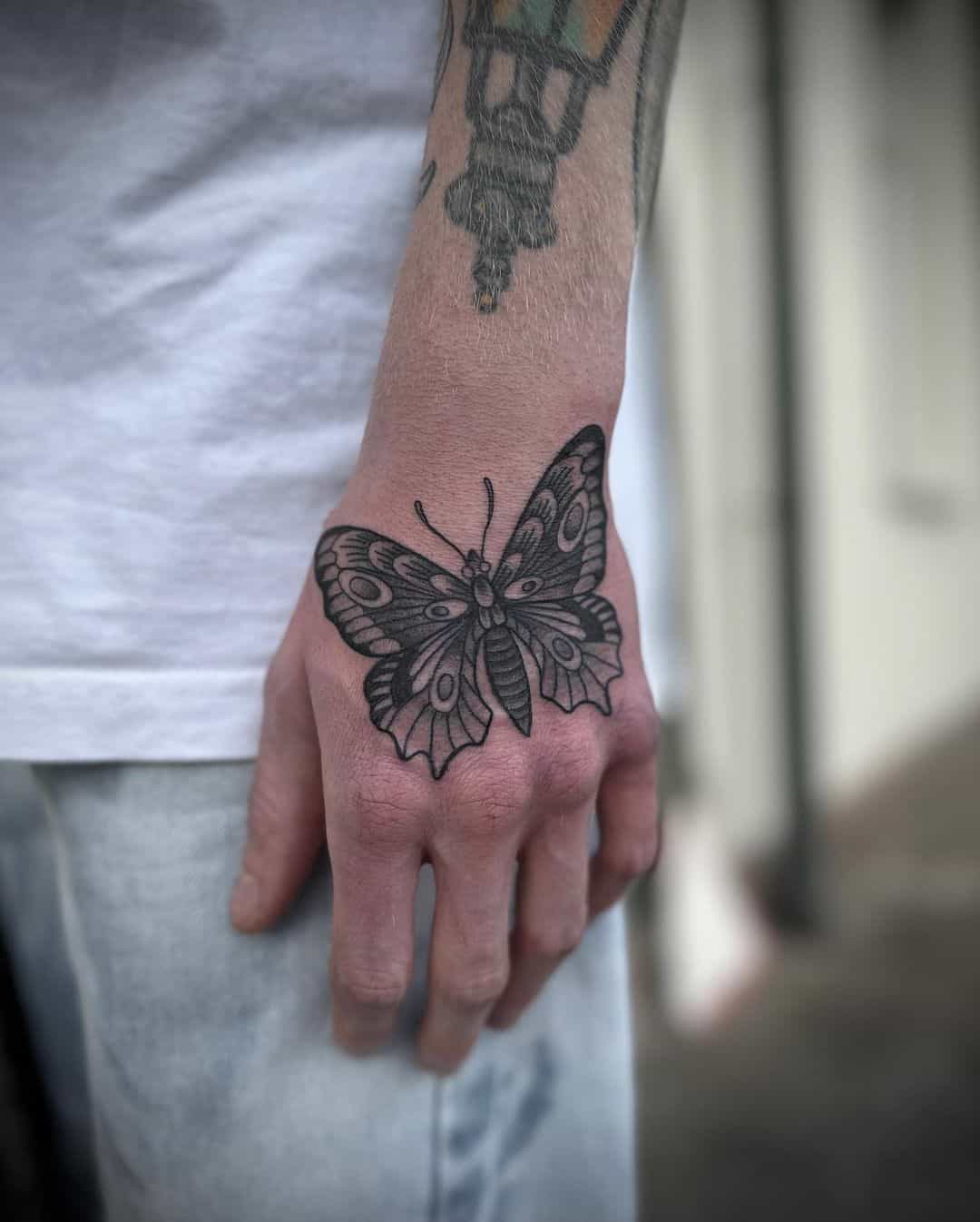 Butterfly on hand tattoo by snacklord3000