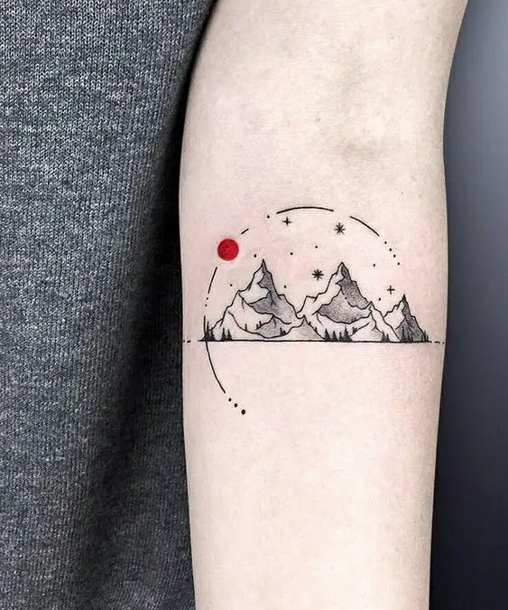 Minimalist sun tattoo on the wrist.