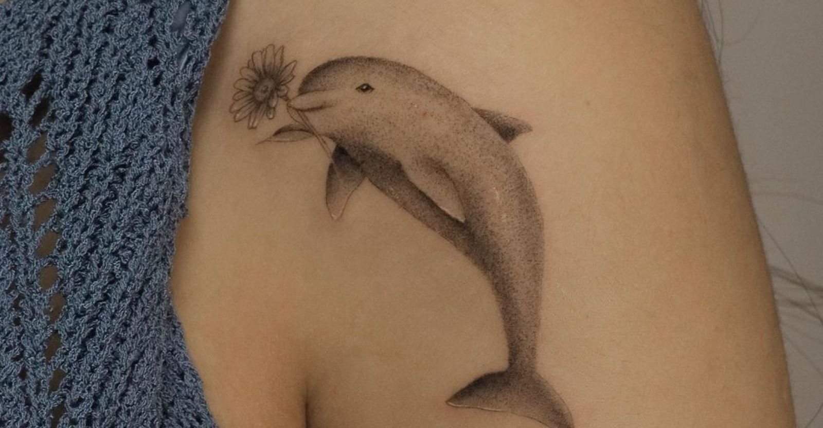 UV Ink dolphin tattoo located on the wrist.