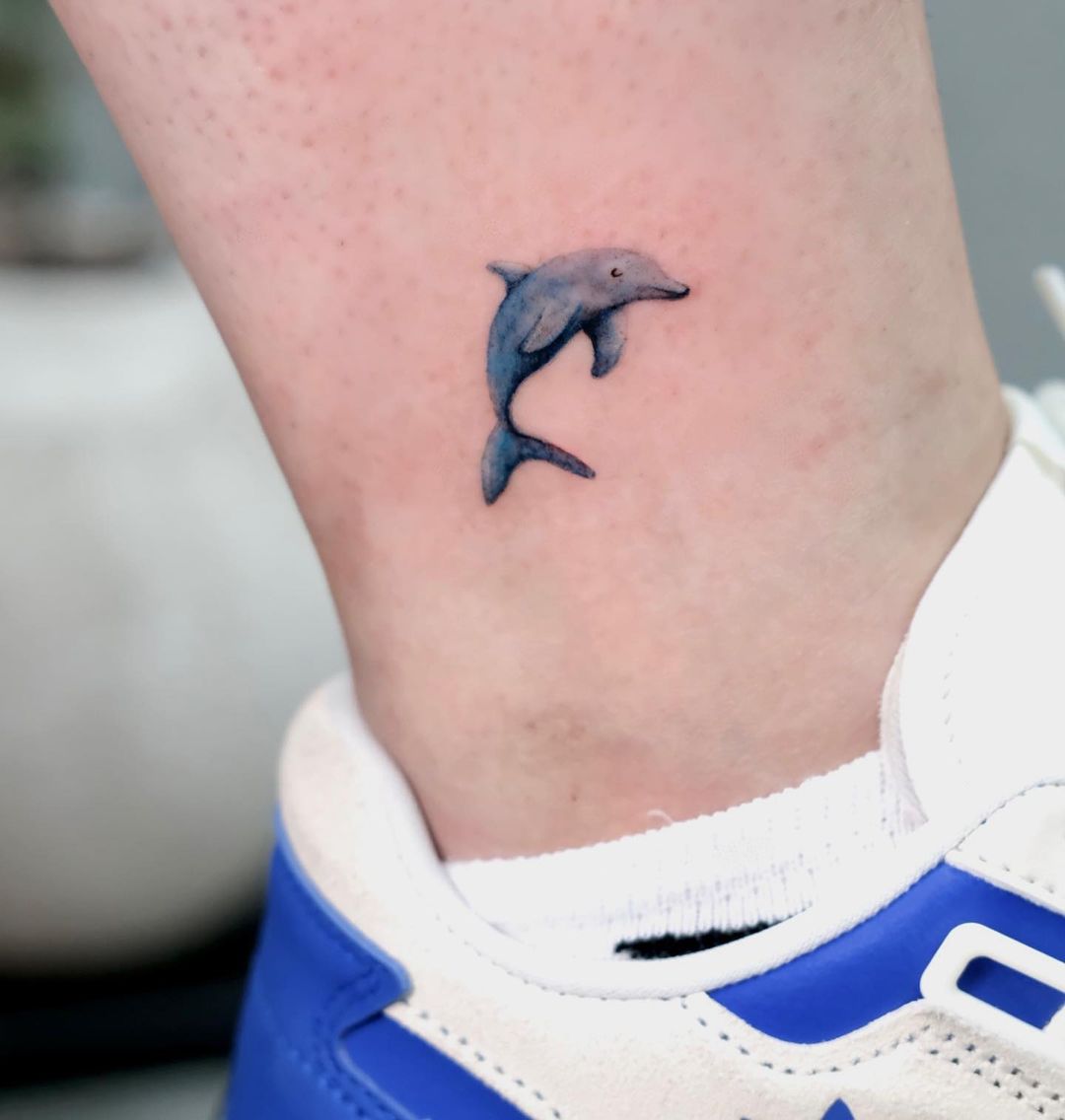 Tiny dolphin tattoo design by cana.umut