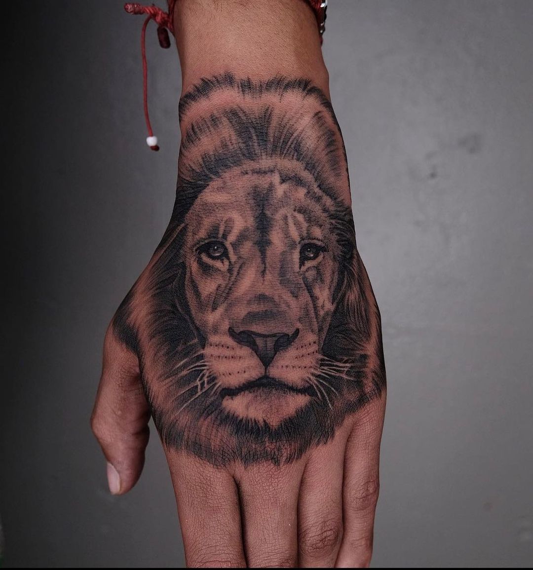 lion tattoo on hand by stockton tattoo