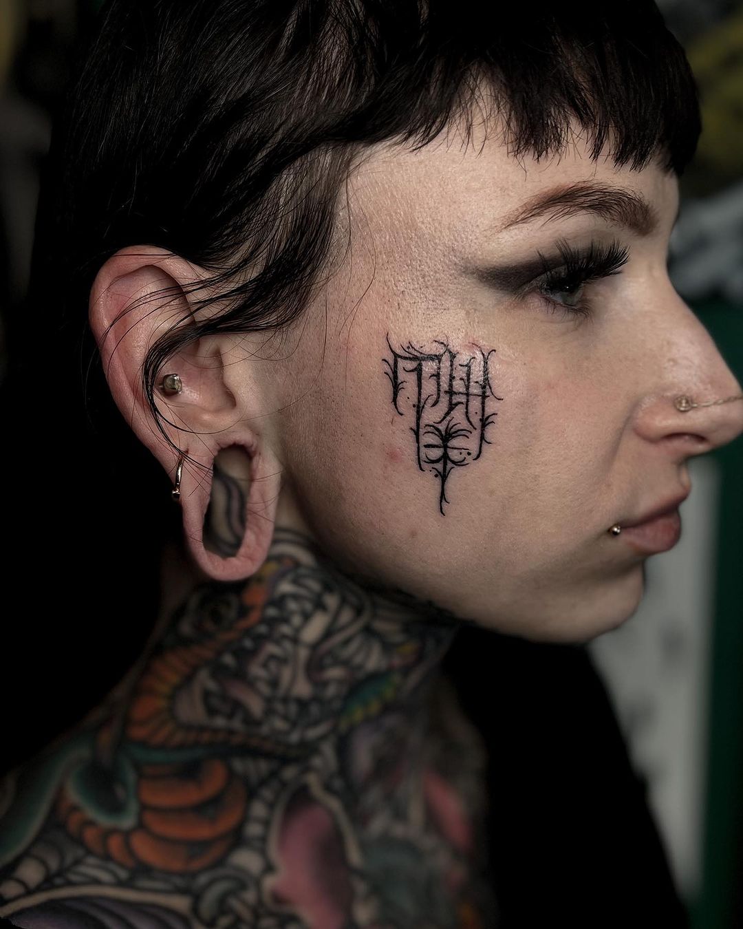 small face tattoo by